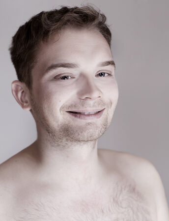 Smiling young handsome man posing, looking at camera.の写真素材