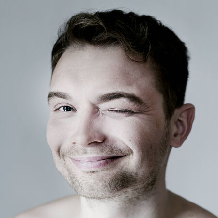 Portrait of young handsome smiling man looking at camera. Studio shot.の写真素材