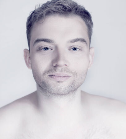 Portrait of young handsome calm man looking at camera. Studio shot.の写真素材