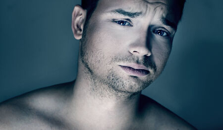 Portrait of young handsome calm man looking at camera. Studio shot.の写真素材