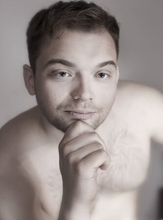 Portrait of young handsome calm man looking at camera. Studio shot.の写真素材