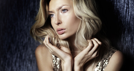 Beauty portrait of elegant attractive blonde woman looking away. Girl with blue eyes and curly long hair.の写真素材
