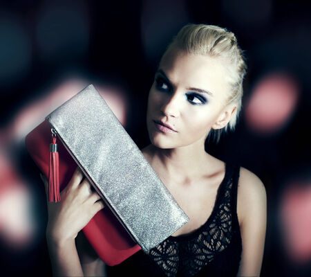 Attractive beautiful blonde woman posing with handbag.の写真素材