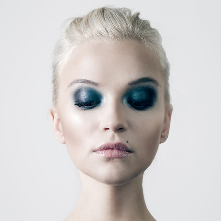 Beautiful sensual blonde woman with perfect makeup and closed eyes posing in studio. Beauty portrait.の写真素材