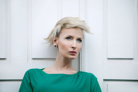 Beautiful blonde woman with short hair posing, looking away.の写真素材