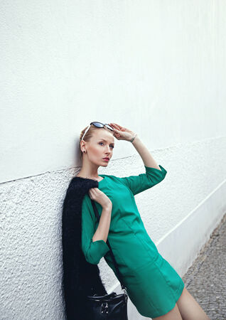 Artistic portrait of beautiful blonde woman looking away, posing over white wall.の写真素材