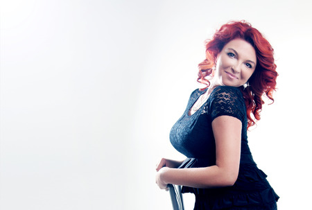 Portrait of beautiful sensual redhead woman with long culry hair and luxury jewelry.の写真素材