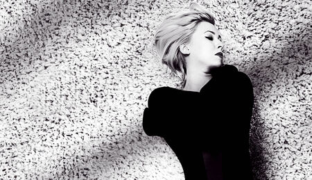 Portrait of beautiful blonde woman lying on carpet with closed eyes.の写真素材