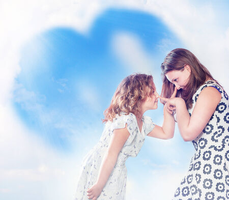 Two young sisters making funny faces, posing over sky background の写真素材