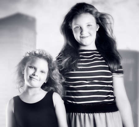Two young sisters portrait  Girls looking at camera の写真素材