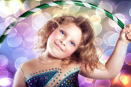 Portrait of pretty little girl with hulahoop looking at camera. Studio photo.の写真素材