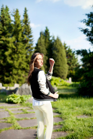 Fashionable brunette young beautiful woman posing on sunny day in park. Summer photo. Girl looking at camera.の写真素材