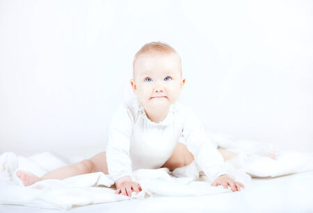 Cute little baby girl posing in studio over white background.の写真素材
