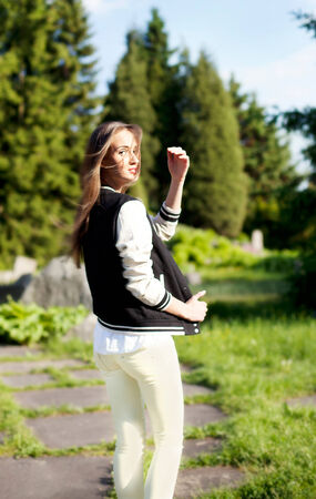 Fashionable brunette young beautiful woman posing on sunny day in park. Summer photo. Girl looking at camera.の写真素材