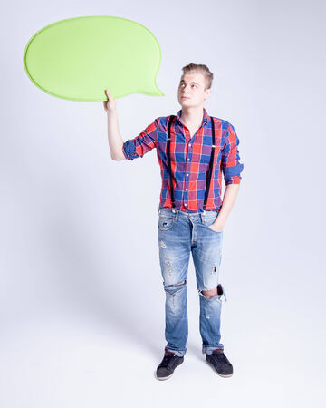Handsome young fashionable man holding empty green board, posing.の写真素材