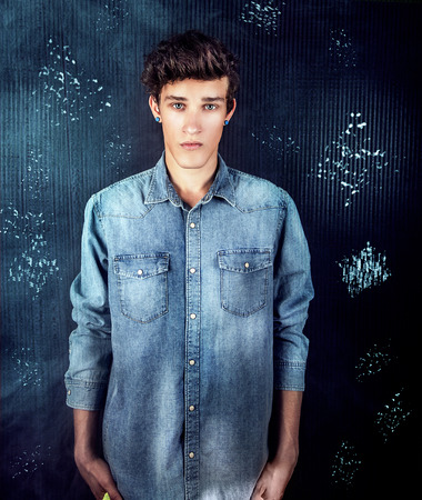 Young handsome male model posing wearing jeans fashionable clothes, studio shot. Man looking at cameraの写真素材