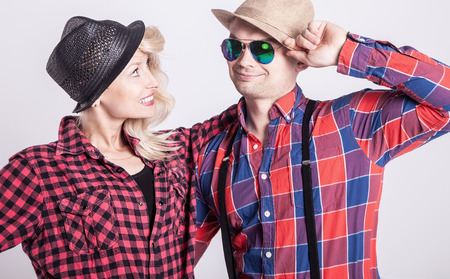 Beautiful blonde young woman posing with handsome man wearing hat, smiling.の写真素材