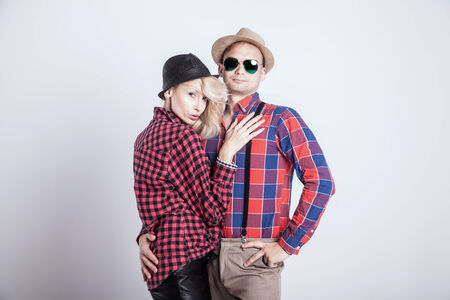 Beautiful blonde young woman posing with handsome man wearing hat, smiling.の写真素材