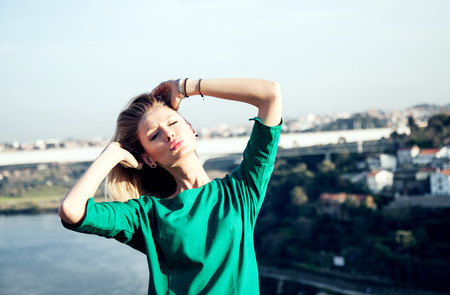 Beautiful blonde woman posing over city view in Portugal at sunny day.の写真素材