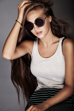 Fashion portrait of beautiful young teenage girl wearing sunglassesの写真素材