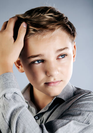 Handsome young teenage boy posing in studio with fashionable hairstyle.の写真素材