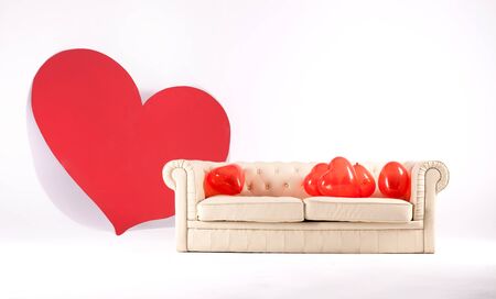 Conceptual photo of empty room with big red heart and balloons on sofa.の写真素材