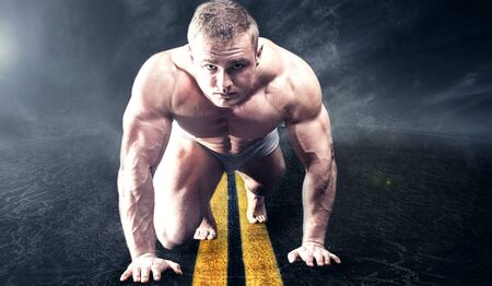 Muscular fit man with perfect body. Starting position.の写真素材