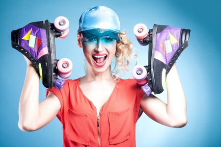 Happy beautiful young woman with roller. Blue background. Smiling girl having fun. Summer photo.の写真素材