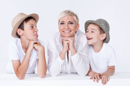 Family photo. Beautiful blonde mother posing with two young boys, looking at camera.の写真素材