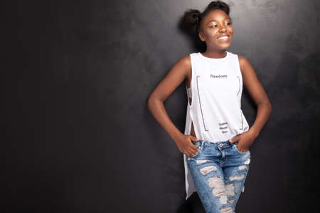 Beautiful young african american girl posing in studio, looking at camera.