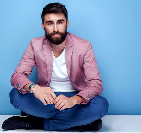 Young handsome man sitting on the floor. Fashion photo. Studio shot.の写真素材