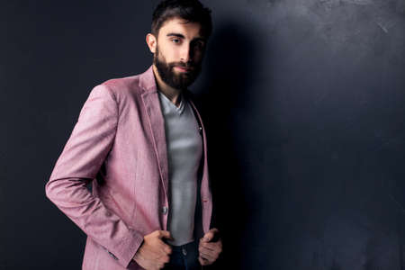 Elegant young handsome man posing in studio, looking at camera. Man with beard.の写真素材