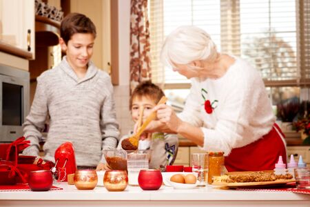 Smiling grandmother baking cookies with young grandchilds. Christmas time. Happiness content.の写真素材