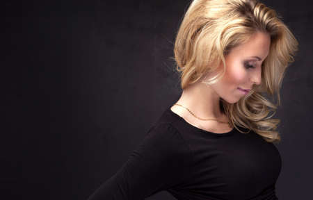 Portrait of blonde attractive woman with long curly hair. Studio shot.の写真素材