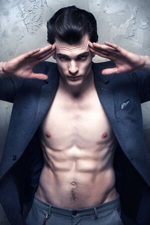 Young handsome athletic man posing in studio, looking at camera.の写真素材