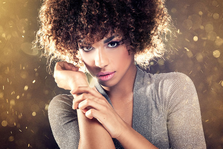 Portrait of beautiful young African American woman with afro and glamour makeup. Studio shot.