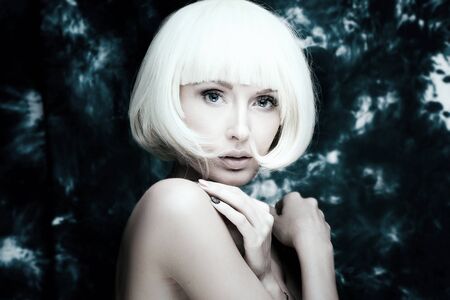 Closeup beauty portrait of stylish young girl with white short hair. Girl looking at camera.の写真素材