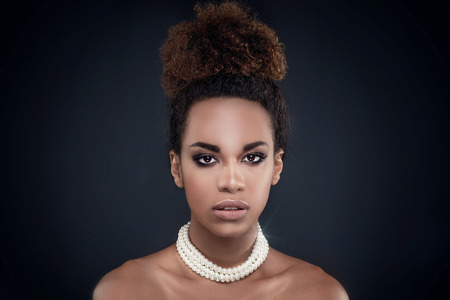 Closeup beauty portrait of elegant african american girl wearing pearls. Glamour makeup. Creative hairstyle.の写真素材