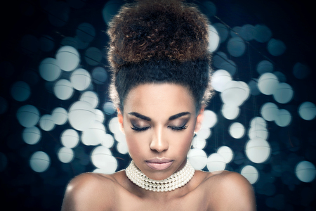 Beauty photo of young elegant african american woman with afro. Girl wearing pearls. Glamour makeup. Studio shot.の写真素材