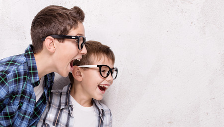 Two young brothers having fun together, smiling. Studio shot.の写真素材