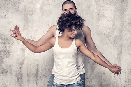 Young beautiful couple posing together, smiling. African american girl with afro and caucasian man. Studio shot.の写真素材