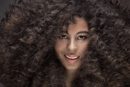 Beauty portrait of sensual african american woman with long curly hair .