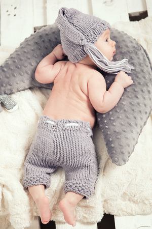 Little cute baby boy lying on grey sheet, looking at camera.の写真素材