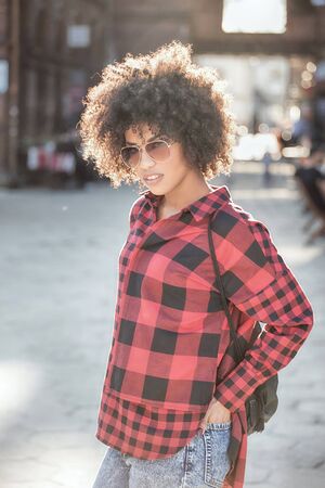 Fashionable young african american woman wearing sunglasses, urban scene.の写真素材