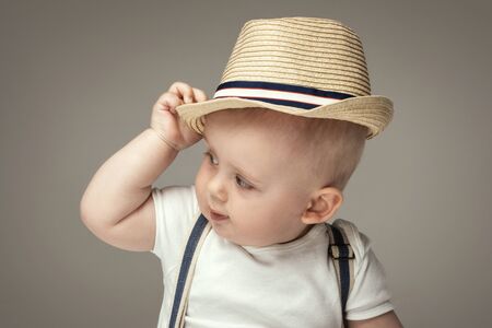 Cute baby boy posing in summer hat. Adorable little child in studio.の写真素材