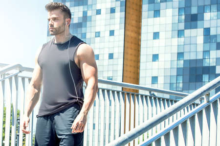 Caucasian handsome male athlete doing exercise outdoor at sunny day.の写真素材