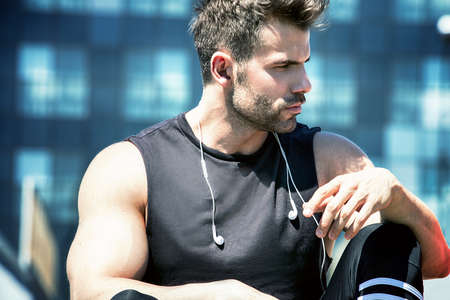 Caucasian handsome male athlete doing exercise outdoor at sunny day.の写真素材