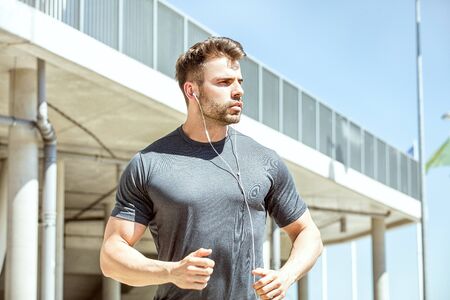 Caucasian handsome male athlete doing exercise outdoor at sunny day.
