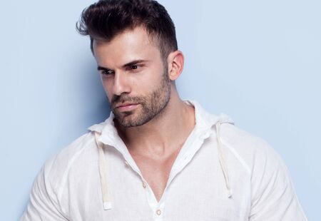 Handsome man posing on blue background.