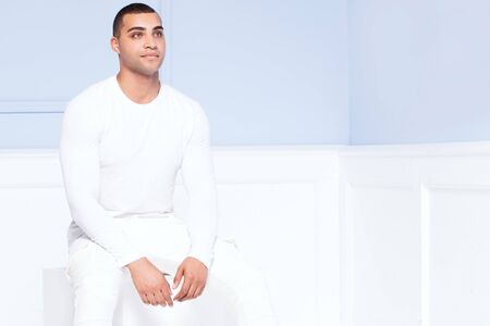 Handsome african american man posing in studio in fashionable white clothes.の写真素材